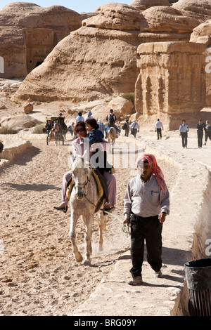 Turistico a passeggiate a cavallo presso il Siq, canyon ingresso alle antiche rocce scolpite città Petra, Giordania. Foto Stock