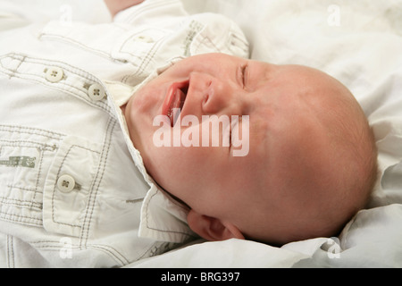 Tre mesi di età bimbo piange con gli occhi chiusi. Foto Stock