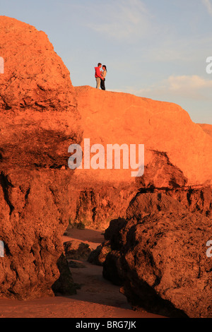 L uomo e la donna sulla sommità della roccia in Praia de Gale, Algarve, PORTOGALLO Foto Stock