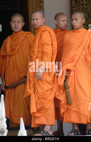 I monaci buddisti stand sotto il portico a loro tempio prima dell'annuale Lao nuovo anno celebrazione a Luang Prabang, Laos. Foto Stock