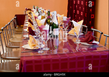 Tavola apparecchiata con stoviglie e piatti per banchetti a bordeaux e toni di colore giallo, shallow DOF Foto Stock