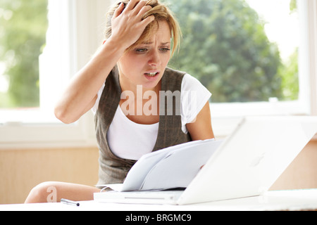 Ha sottolineato la ragazza guardando le bollette Foto Stock