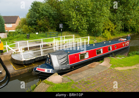 Un canal narrowboat passando un ponte girevole sul Ashton canal a Droylsden, Tameside, Manchester, Inghilterra, Regno Unito Foto Stock