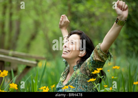 Donna felice prendendo un respiro nella splendida natura della molla Foto Stock