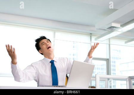 Frustrato il lavoro di ufficio alla sua scrivania Foto Stock