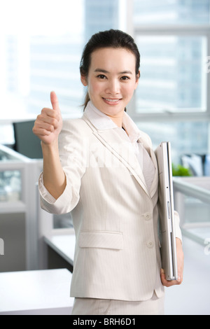 Lavoratore di ufficio dando pollice in alto Foto Stock