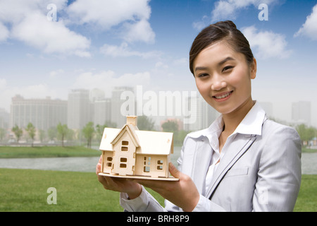 Donna che mantiene un modello di casa Foto Stock