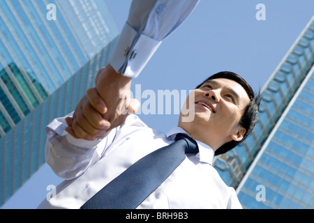 Imprenditore stringono le mani in una scena urbana Foto Stock