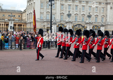 Queen's guardie marzo fuori Buckingham Palace durante il cambio della guardia Foto Stock