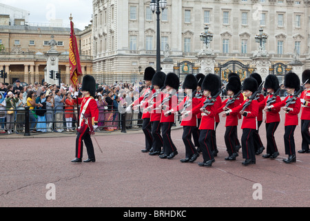 Queen's guardie marzo fuori Buckingham Palace durante il cambio della guardia Foto Stock