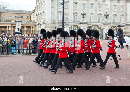 Queen's guardie marzo fuori Buckingham Palace durante il cambio della guardia Foto Stock