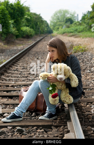 Ragazza seduta su binari ferroviari Foto Stock