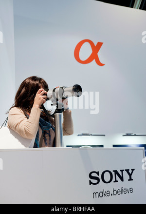 Visitatore femmina usando fotocamera Sony e la lente a Photokina digital imaging trade show di Colonia Germania Foto Stock