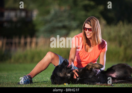 La donna e il suo cane giocando in un Parco Steamboat Springs, Colorado, STATI UNITI D'AMERICA Foto Stock