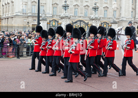 Queen's guardie marzo fuori Buckingham Palace durante il cambio della guardia Foto Stock