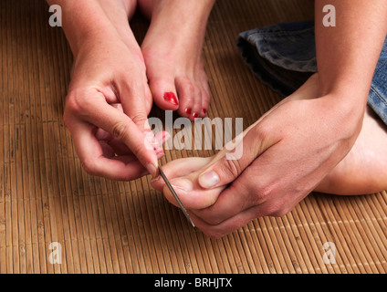 Close-up di donna le mani dell uomo e i piedi come ella gli dà una pedicure Foto Stock