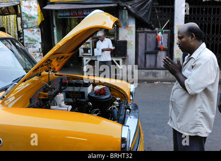 India Calcutta Kolkata , Kali Ghat, taxi driver benedire la sua nuova cabina , un HM Ambassador auto che si basa sulla Oxford Morris modello e ancora prodotta Foto Stock