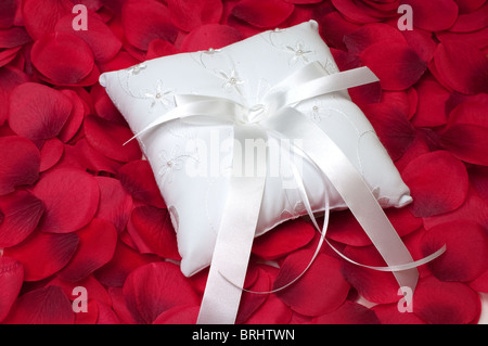 Anello del portatore dei cuscini sul letto di rosso petali di rosa. Foto Stock