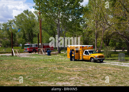 Un incendio rurale servizi paramedici di trattare un uomo ferito da un albero di caduta Foto Stock