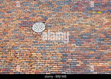 Ybor City, FL - Luglio 2009 - ghisa handhole utilità in mattoni colorati strada asfaltata a Ybor City zona di Tampa, Florida Foto Stock