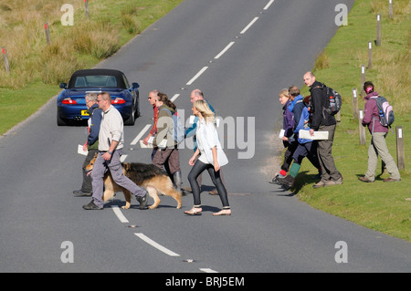 Gruppo di persone che attraversano la strada per escursionisti e turisti nel Parco Nazionale di Dartmoor nel Devon England Regno Unito Foto Stock