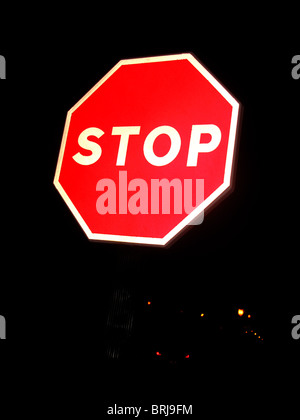 Ottagonale di stop rosso contro lo sfondo scuro Foto Stock