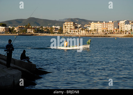 La pesca dalla scogliera, e piccole barche da pesca, Javea / Xabia, Provincia de Alicante, Comunidad Valenciana, Spagna Foto Stock