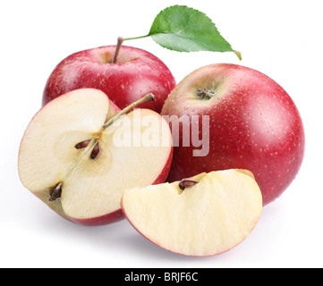 Due red apple con foglie e fette di mela isolato su uno sfondo bianco. Foto Stock