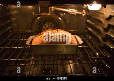 Pane alla banana a bruciare in un forno, oltre la cottura, girando il marrone scuro Foto Stock