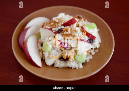 Una piastra di apple insalata di noce (simile a Insalata Waldorf senza mayo) su una piastra di colore blu con fette Foto Stock