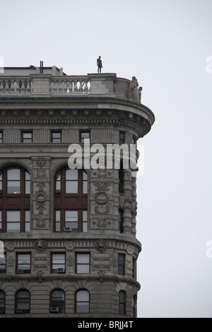 Parte superiore del Flat Iron Building con la scultura di uomo in piedi sul bordo per 'Event Horizon New York" Foto Stock