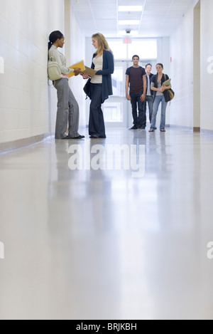 Gli studenti delle scuole superiori di parlare nel corridoio della scuola Foto Stock