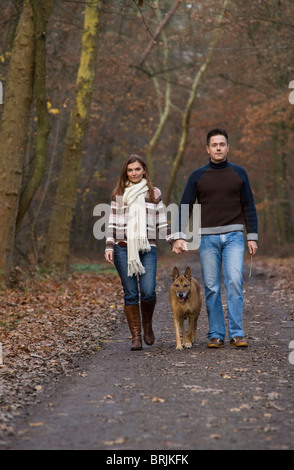 Giovane a piedi il loro cane nella foresta Foto Stock