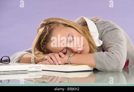 Donna di addormentarsi alla scrivania Foto Stock