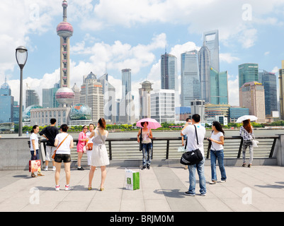 Il Bund, Shanghai, Cina. I turisti cinesi fotografia ogni altro sul Bund contro sfondo del Distretto di Pudong skyline tower Foto Stock