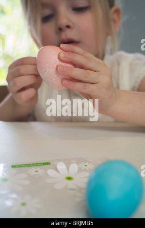 Bambina decorare le uova di Pasqua Foto Stock