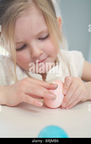 Bambina decorare le uova di Pasqua Foto Stock