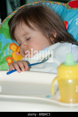 Il bambino dorme nella sedia alta Foto Stock