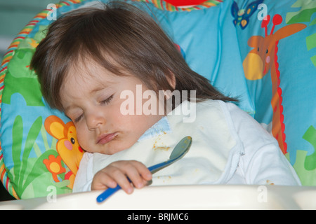 Il bambino dorme nella sedia alta Foto Stock