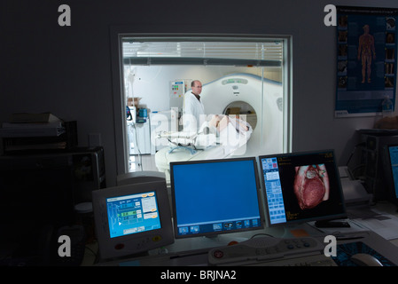Medico maschio in piedi accanto al paziente di sesso femminile avente CAT scan Foto Stock