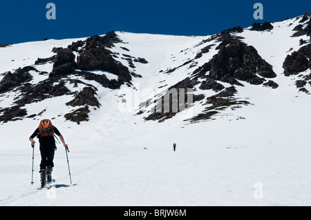 Durante il suo ultimo tour di sci per la stagione, un giovane uomo di pelli per il vertice di giugno del lago, California. Foto Stock