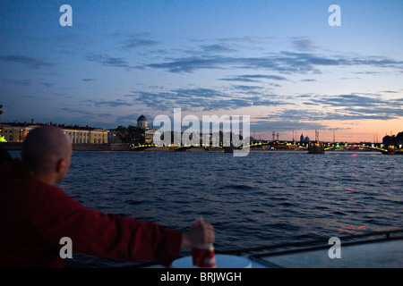 Uomo locale oltrepassando Isola Vasilievsky su una gita in barca sul fiume Neva durante le notti bianche Foto Stock