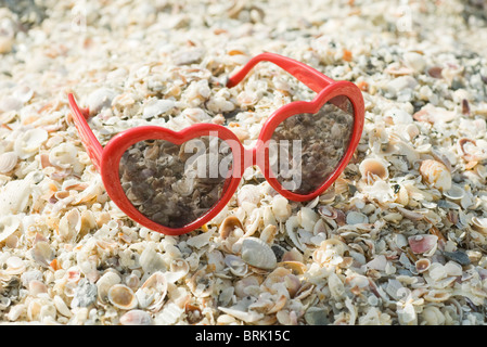 A forma di cuore occhiali da sole sulla spiaggia Foto Stock