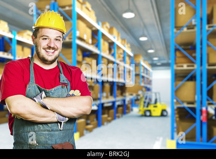 Sorridenti giovani caucasici lavoratore manuale in magazzino Foto Stock