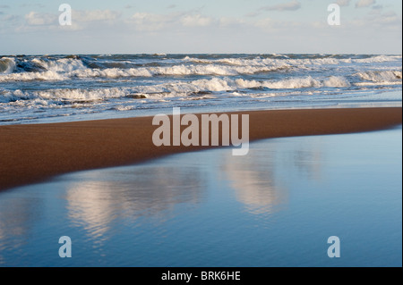 Mare mosso di onde che si infrangono sulla spiaggia Foto Stock