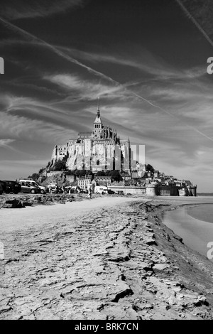 Drammatica ampio angolo bianco e nero Mont St Michel visto dalla spiaggia parcheggio auto Foto Stock