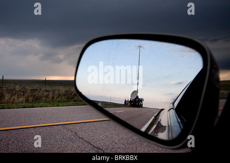 Shot attraverso uno specchietto retrovisore, un Doppler su ruote carrello esegue una scansione temporale supercellular nelle zone rurali del Wyoming, 21 maggio 2010. Foto Stock