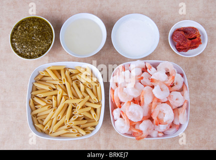 Mise en place setup di ingredienti per i gamberi pesto sulla penne con pomodoro secco Foto Stock