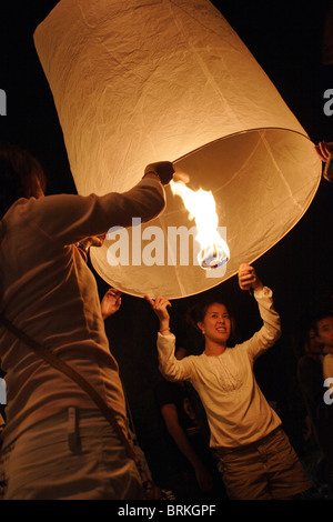 Un uomo e una donna la luce di una lanterna Lanna (Khom Loy, Loi) all'annuale Loi krathong Festival in Chiang Mai, Thailandia. Foto Stock