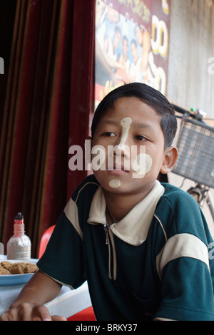 Un ragazzo indossa una sostanza protettiva per proteggersi dal caldo sole birmano in Myawaddy, Birmania (Myanmar). Foto Stock